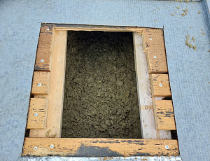 Zateplení stropu zděné budovy s nízkou dvouplášťovou střechou pomocí foukané izolace 